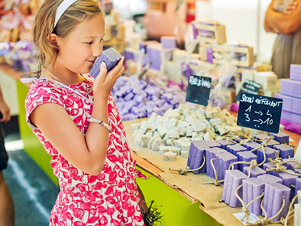 girl smelling a bar of soap at a craft fair